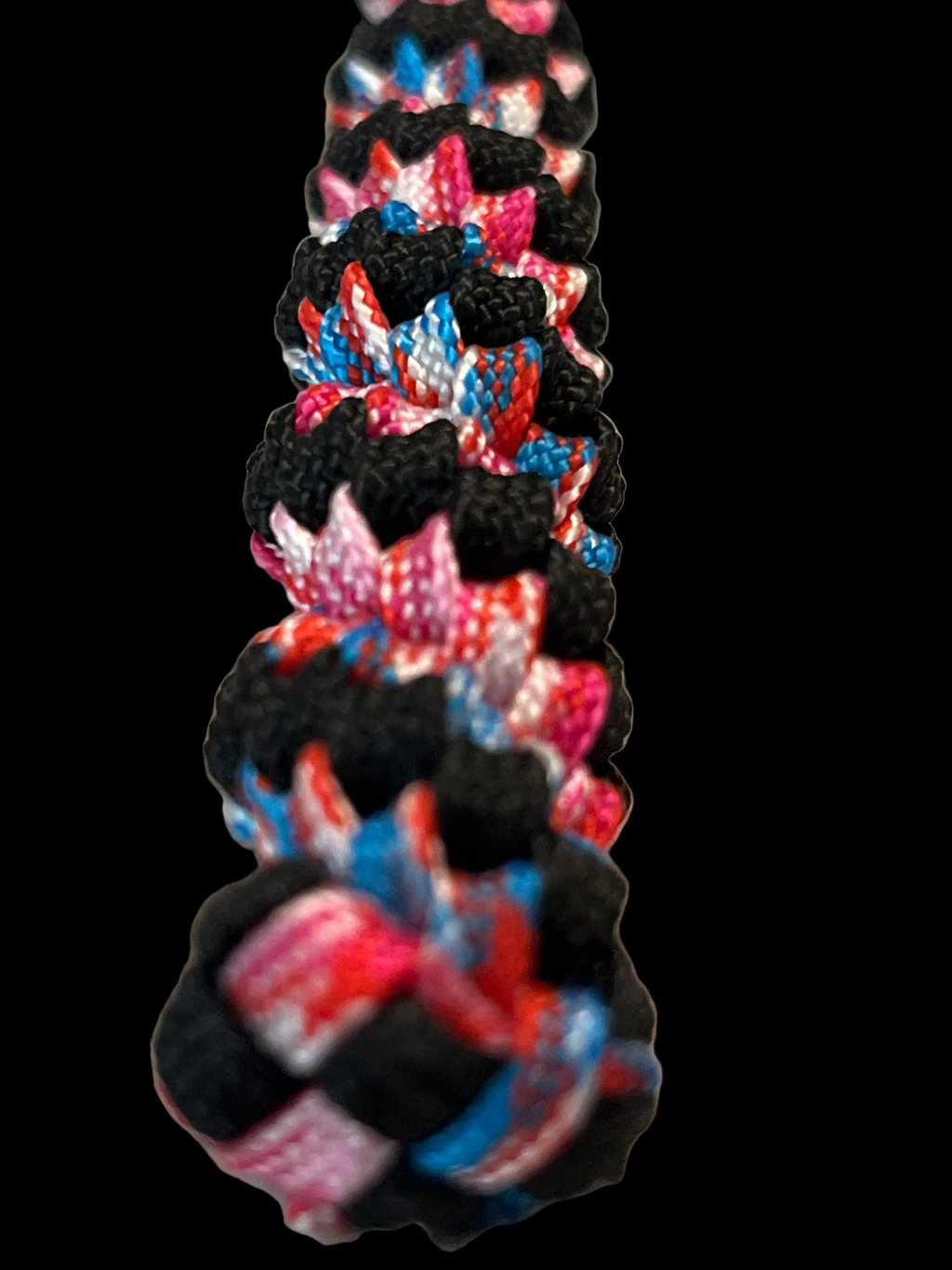 Colorful braided rope with black, red, blue, and pink pattern on a transparent background
